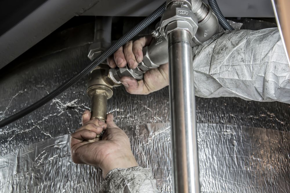 Plombier serrant un raccord de canalisation avec une clé